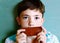 Preteen handsome boy with chocolate piece on blue