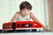 Preteen handsome boy play with meccano toy train