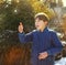 preteen handsome boy toss a coin on the country spring sunny village background