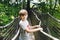 Preteen kid boy walking on high tree-canopy trail with wooden walkway and ropeways on Hoherodskopf in Germany. Happy