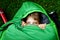 Preteen school kid boy in sleeping bag camping. Outdoors activity with children in summer. Fun and adventure camp