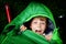 Preteen school kid boy in sleeping bag camping. Outdoors activity with children in summer. Fun and adventure camp, family and