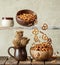 pretsels falling out from a wooden bowl to another bowl, on wooden background, kitchen setup. levitating trend photo