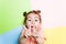 Pretty 4-year little girl with funny face on multicolor background. Bright colors and stylish picture