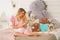 Pretty adult girl with her secret diary in her white bedroom with many plush teddy bears