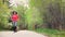 Pretty African American woman running and exercising in the park or woods.