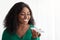 Pretty african american woman standing by window, recording message, using cellphone