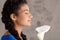 Pretty african girl in profile smiling, holding white flower.