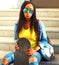 Pretty african woman with skateboard in sunglasses