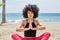 Pretty afro american woman meditating on beach