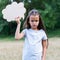 Pretty angry sad thinking little girl posing summer nature outdoor with cloud of thoughts like in comic book. Kid`s portrait.