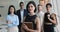 Pretty Armenian businesswoman posing for camera with multiethnic teammates