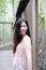 Pretty Asain girl is smiling and sitting on wooden bridge in the tropical mangrove forest.