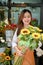 Pretty Asian female florist or floral shop owner holding a sunflower bouquet