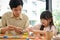 Pretty Asian girl concentrating sculpting play dough, making a colorful clay with her art teacher