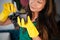 Pretty asian woman in a green apron replanting a home plant Cereus succulent cactus in gloves in pot, home plant care concept