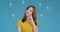 Pretty asian woman having question emotional thinking reaction on blue background studio shot