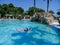 Pretty athletic sun tanned girl floating on a pool float in a beautiful swimming pool on vacation