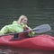 pretty athletic woman with blond hair is happy to operate a sports kayak boat.