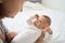 Pretty baby boy on mother hands in room closeup. Motherhood. Childhood.