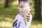 Pretty baby kid hold in hand ice cream in waffles coneon. Pretty little kid holding an ice cream outdoors