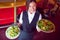 Pretty barmaid holding plates of salads