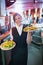 Pretty barmaid holding plates of salads