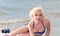 Pretty blond girl model like Marilyn Monroe with surfing board on a beach