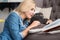 Pretty blond woman reading book with her cat