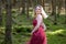 Pretty blond woman turning around against trees in woods