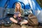 Pretty blonde camper using tablet and sitting in tent