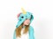 Pretty blonde girl with cozy blue unicorn costume is posing in the studio in front of white wall and is happy