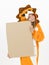 Pretty blonde girl with cozy lion costume is holding a brown sign in the studio in front of white wall