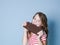 Pretty blonde girl with a giant bar of chocolate is posing in front of blue background and is happy smiling