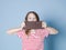 Pretty blonde girl with a giant bar of chocolate is posing in front of blue background and is happy smiling