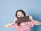 Pretty blonde girl with a giant bar of chocolate is posing in front of blue background and is happy smiling