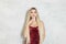 Pretty blonde woman celebrity with long shiny hair wearing red dress