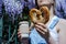 Pretty blonde woman holding cup of coffee and sweet pretzel in a