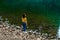 Pretty brunette girl enjoying mountains lanscape, standing near lake.