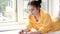 pretty brunette girl in yellow hoodie arranging pieces of a Jigsaw Puzzle Game in bright white room. playing board game