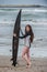 Pretty brunette standing surf board up on tail.