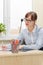 pretty business woman in glasses in the office at the working table by the window signs documents