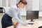 Pretty business woman in glasses in the office at the working table by the window signs documents