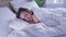 Pretty calm woman sleeping well alone on her side in comfortable bed. Lady with happy face and smile in light cozy