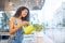 Pretty caring woman watering houseplant in cafe