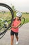 Pretty Caucasian Sportswoman Works Out with Bicycle Outside