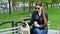 Pretty caucasian woman with funny pug dog sitting on bench and drinking coffee