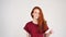 Pretty cheerful redhead girl laughs on the camera on white background in slow motion.