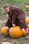 Pretty child picking a pumpkin