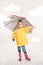 pretty child in rubber boots, yellow raincoat with umbrella,